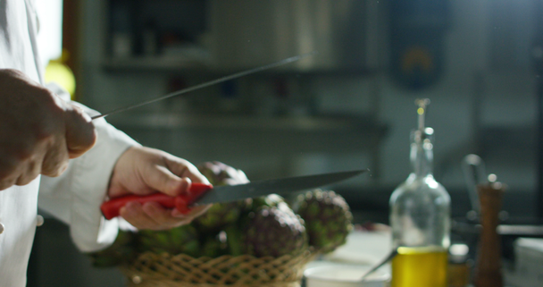 la mano de un joven chef experto toque suavemente y elija uno de los ingredientes que va a utilizar para su receta, alcachofas
 - Imágenes, Vídeo
