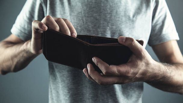 Caucasian man holding empty leather wallet. - Фото, изображение