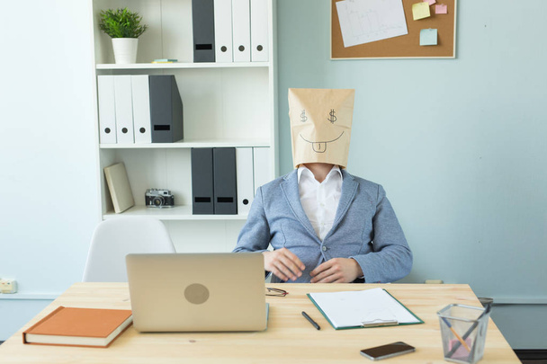 Negócios, emoções e conceito de dinheiro - homem louco escritório colocar um pacote com rosto engraçado pintado em sua cabeça. Sinal de dólar nos olhos
 - Foto, Imagem