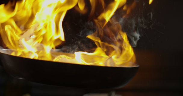 ervaren chef-kok koken op hoog vuur met de pan in een professionele keuken met groenten - Video