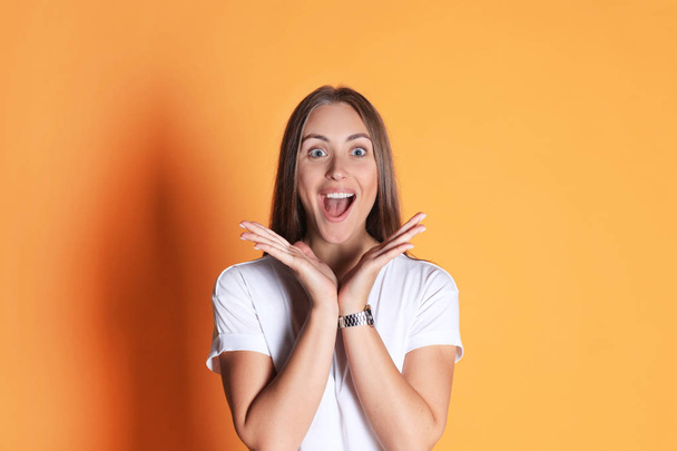 Young woman in casual clothing wondering and screaming isolated over yellow background. - Photo, Image