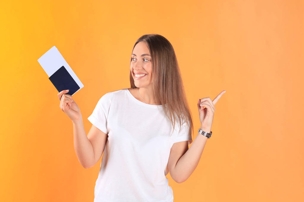 Enthousiast jonge vrouw toeristische permanent geïsoleerd op gele achtergrond met paspoort met kaartjes. - Foto, afbeelding