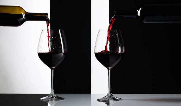 Red wine is poured into a glasses. Reflexive background, copy space for your text. - Zdjęcie, obraz