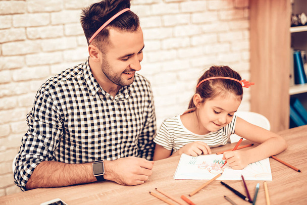 Father and Daughter on Sofa. Spend Time Together. Father's day. White Interior. Headband Hair on Head. Cakes on Plates. Bottle with Topping in Hand. Draw Picture. Take Selfie. Colour Pencils. - Photo, image