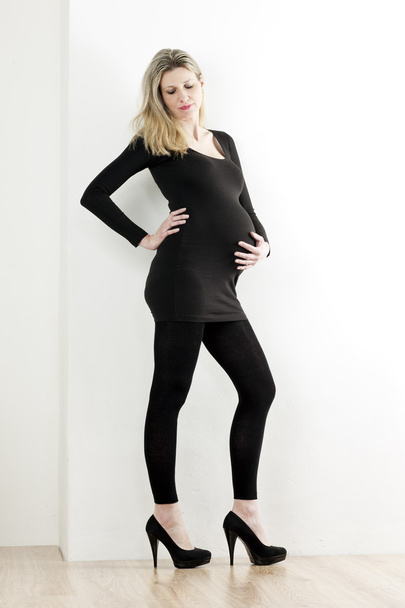 mulher grávida vestindo roupas pretas e bombas
 - Foto, Imagem