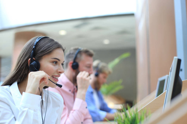Attractive positive young businesspeople and colleagues in a call center office. - Photo, Image