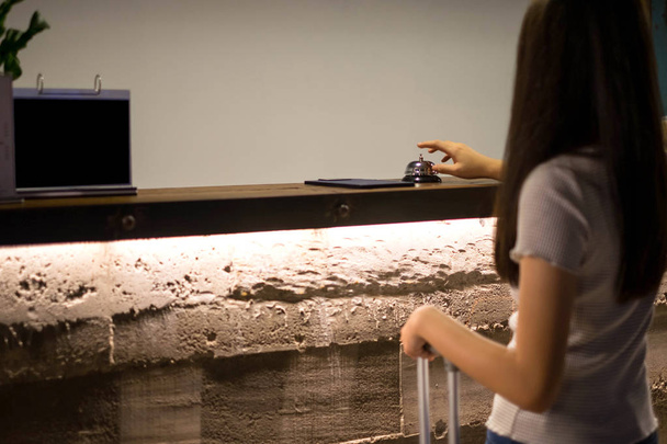 Close up women call hotel reception on counter desk with finger push a bell in lobby hotel. hotel concept. - Photo, Image