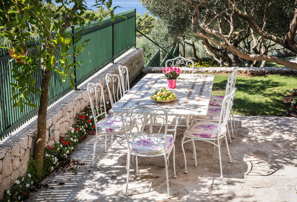 Beau jardin, table préparée pour un repas et vue sur la mer Méditerranée
 - Photo, image