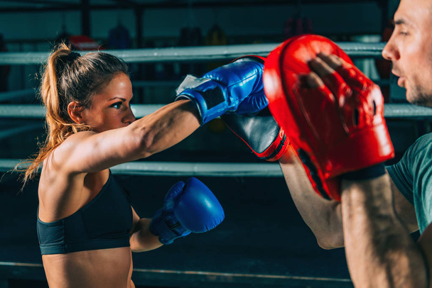 Женщина на тренировке по боксу с личным тренером
 - Фото, изображение