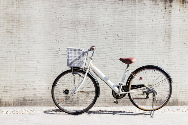 Fahrrad mit Korb vor der weißen Wand, Hintergrund - Foto, Bild