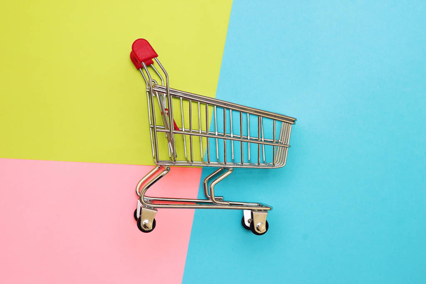 Önkiszolgáló szupermarket teljes kocsi kosár színes háttérrel - Fotó, kép