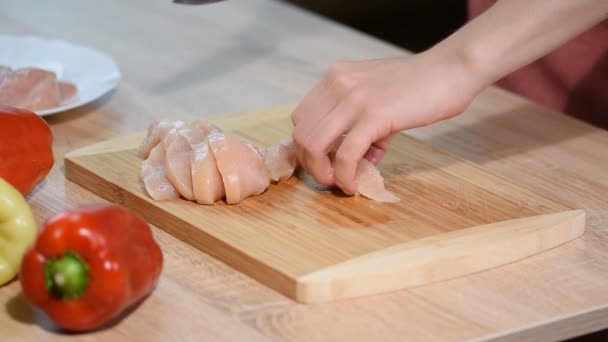 Chef woman cuts chicken at the kitchen. - Кадри, відео
