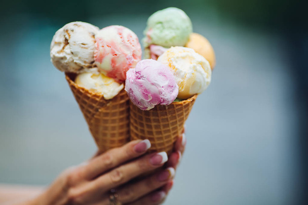 Crop of womans hand holding delicious colorful ice cream. - Fotografie, Obrázek