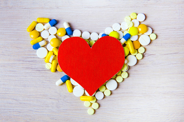Red Heart Shape with a Pills on the Table closeup - 写真・画像