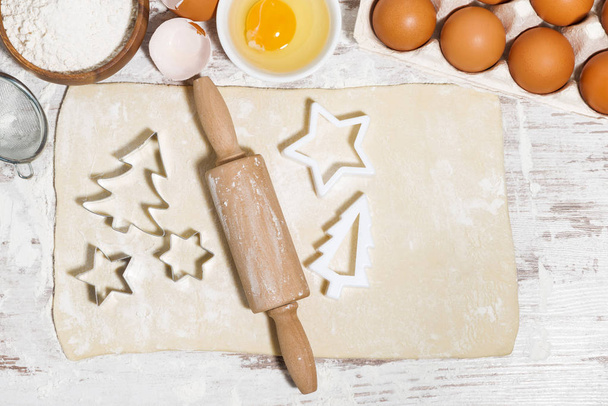 Ingredients for baking Christmas cookies. Dough, cookie cutters and rolling pin, top view horizontal - Photo, image
