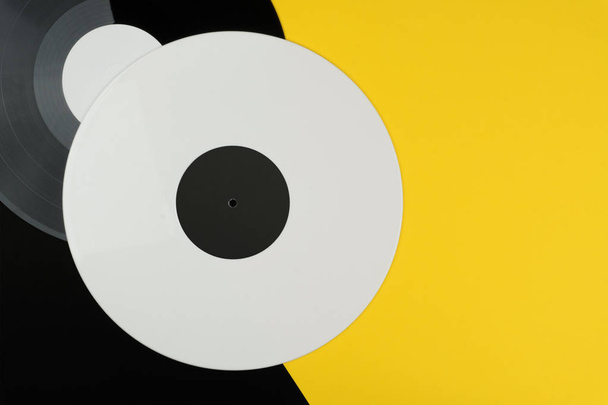 vista superior de um disco de vinil branco e preto longo sobre o fundo preto e amarelo
 - Foto, Imagem