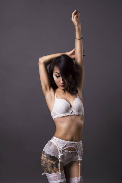 Φωτογραφία: το σέξι κορίτσι της Ασίας με tatoo στα λευκά εσώρουχα  - Φωτογραφία, εικόνα