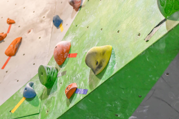 Kiipeilyseinä lohkarehallissa värillisillä koukuilla
 - Valokuva, kuva