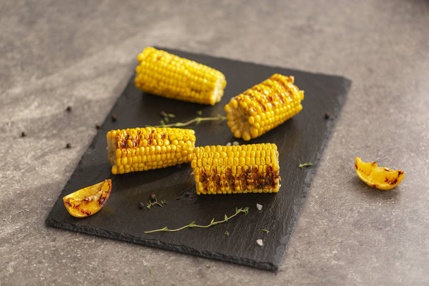 Grilled corn grilled on fire. On a dark stone table. - Fotó, kép