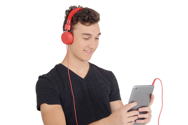 Teenage boy using tablet with headphones. Technology concept. Isolated white background - Foto, imagen
