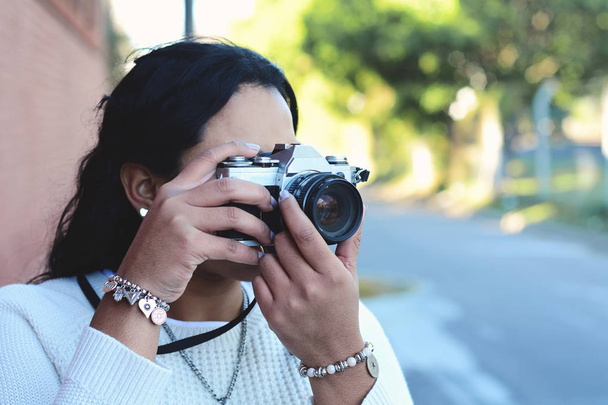 portrait of young woman having fun taking photos with retro film camera. Outdoor lifestyle portrait. - Φωτογραφία, εικόνα