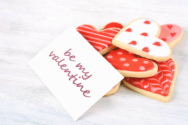 Close up of Valentine's day cookies with greeting card on pink background - Zdjęcie, obraz