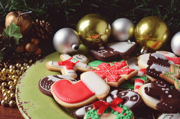 Plate with colorful christmas cookies on wooden table. xmas holiday concept. - Foto, immagini