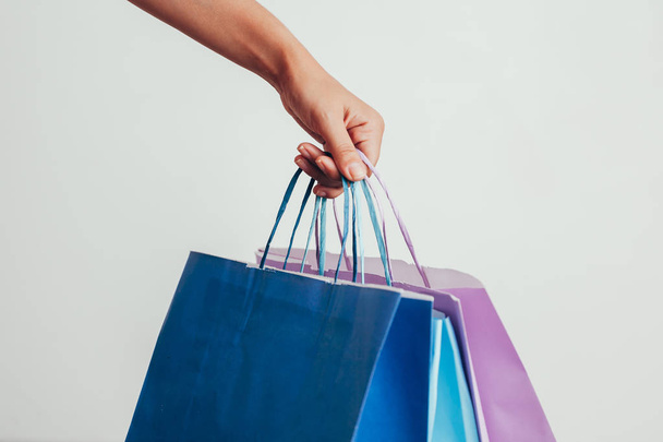personas, venta, consumismo, publicidad y concepto de viernes negro - primer plano de la mano sosteniendo bolsas de compras
 - Foto, imagen