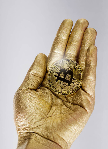 Kultainen käsi pitää fyysinen kolikko kryptovaluutta Bitcoin
. - Valokuva, kuva