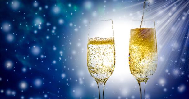 Two glass of champagne wine close-up with bubbles and fizz, on beautiful Christmas and New Year`s background with falling snow and free space for text - Фото, зображення