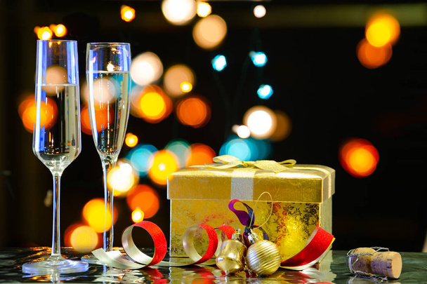 Christmas composition with a glass of sparkling wine, Christmas decorations and cork, on a dark background with blurred lights of the city. - 写真・画像