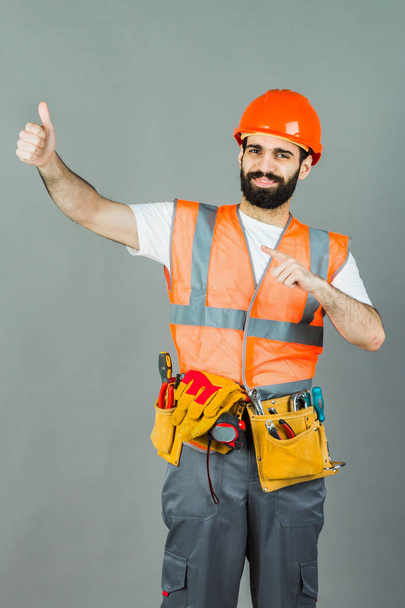 Man Builder avec barbe debout sur fond gris, espace de copie
 - Photo, image
