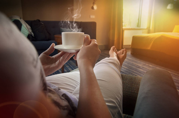 Donna rilassante con tè o caffè in camera da letto durante il pomeriggio di sole
 - Foto, immagini