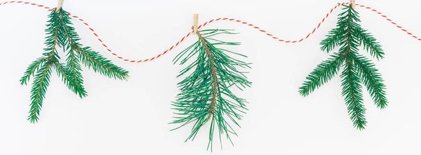 Yeni yıl veya Noel kompozisyon düz yatıyordu üstten görünüm Xmas tatil kutlama el yapımı elişi garland ile köknar ağacı çam dalları beyaz arka plan kopya alanı uzun geniş afiş - Fotoğraf, Görsel