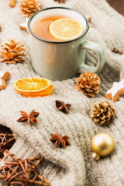 Kış ve yılbaşı tema. Noel çay baharat, çay portakal, tarçın, anason, yıldız, çam kozalakları, biber ve ahşap arka plan üzerinde gri eşarp şeklinde kurabiye ile. Metin için yer kopyalayın. - Fotoğraf, Görsel