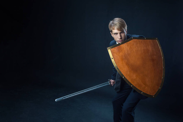 Businessman with shield and sword. Risk management and information protection concept - Foto, Bild