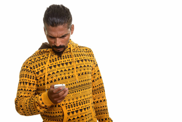 Fiatal indiai ember használ mozgatható telefon stúdió portré fehér háttér - Fotó, kép