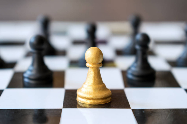 Vedoucí hlavní zlaté pěšec stojí před další běžné pěšci v šachové hře na černobílou šachovnici. Obchodní strategie společnosti, vítězství, rozhodnutí, úspěchu, věřit v sebe, moc, vedení - Fotografie, Obrázek