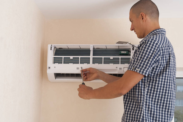 trabalhador instala a unidade de ar condicionado interior na parede
 - Foto, Imagem