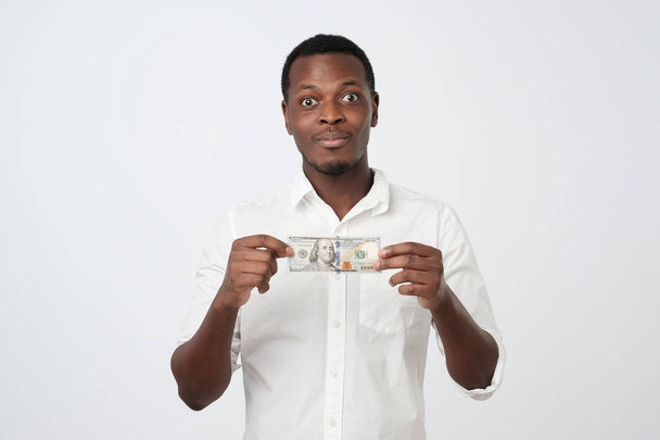 Щасливий радісний красивий африканський молодий бізнесмен тримає долари
. - Фото, зображення