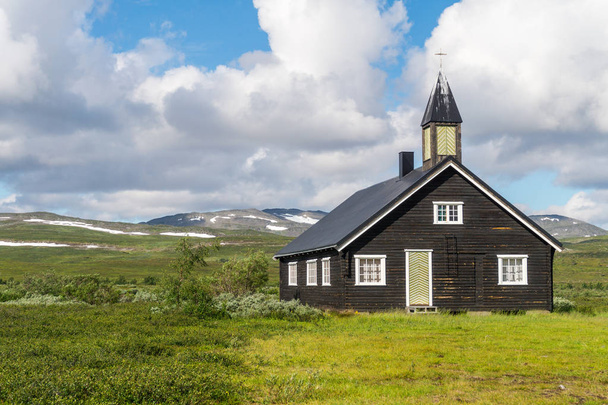 Wooden church on a green meadow against a background of a cloudy sky, Finnmark, Norway - Zdjęcie, obraz