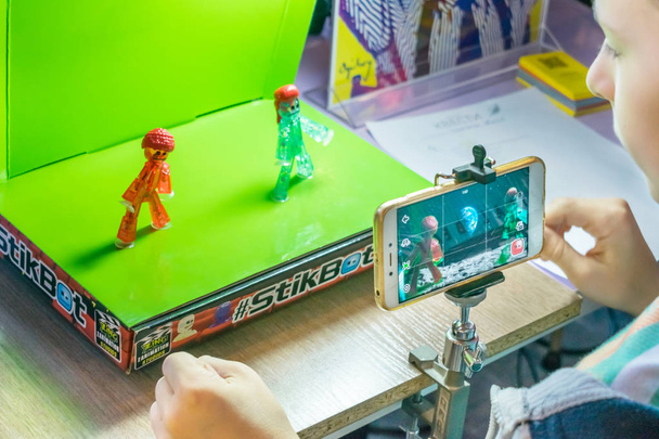 Stop motion animation process with Stikbot details and toy figures. Boy expose stop motion elements to create animations using smartphone - Photo, Image