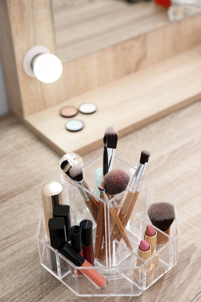 Organizer with cosmetic products for makeup on table near mirror - Foto, Imagem