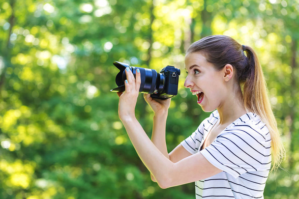 Young woman with a professional camera - 写真・画像