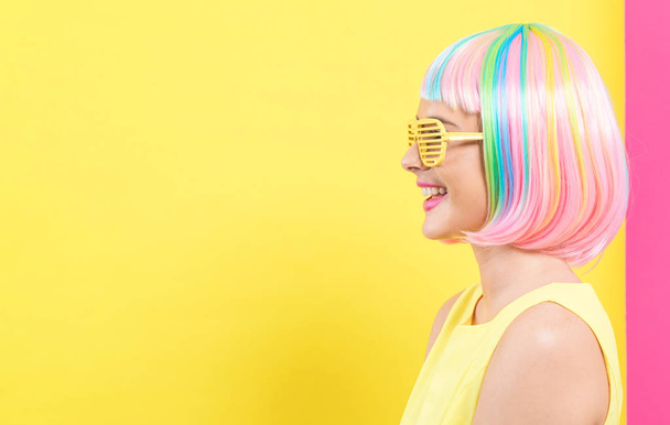 Žena nosí závěrky komentovaný sluneční brýle v barevné paruky - Fotografie, Obrázek