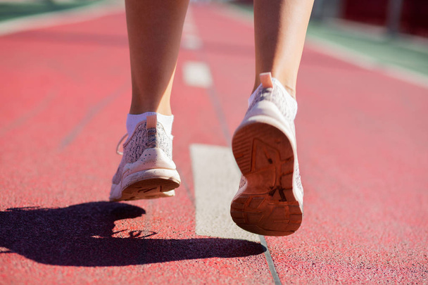 Крупним планом знімок жіночих ніг бігу на біговій доріжці в сонячному світлі
 - Фото, зображення