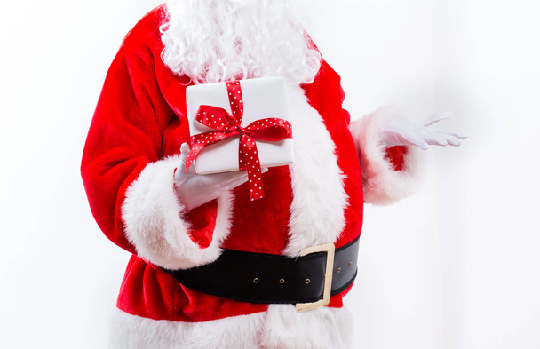 Santa holding a Christmas gift - Foto, afbeelding