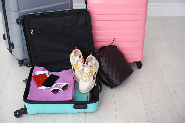 Modern suitcases on light floor. Travelling preparations - Valokuva, kuva