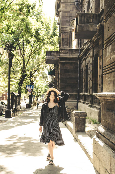 Beautiful fashionable woman walking  in black dress and jeans in city  - Zdjęcie, obraz