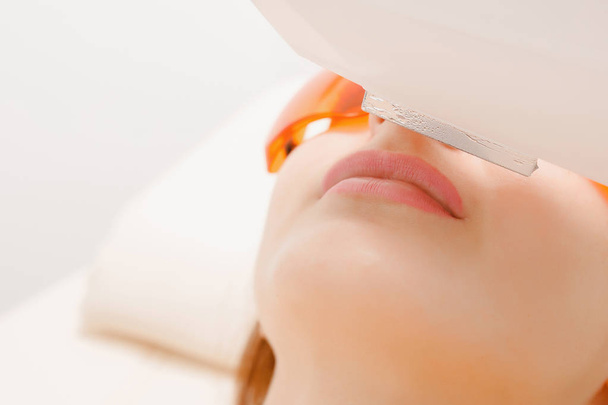 Процесс лазерной удаления волос лечение в салоне молодая женщина с усами
. - Фото, изображение